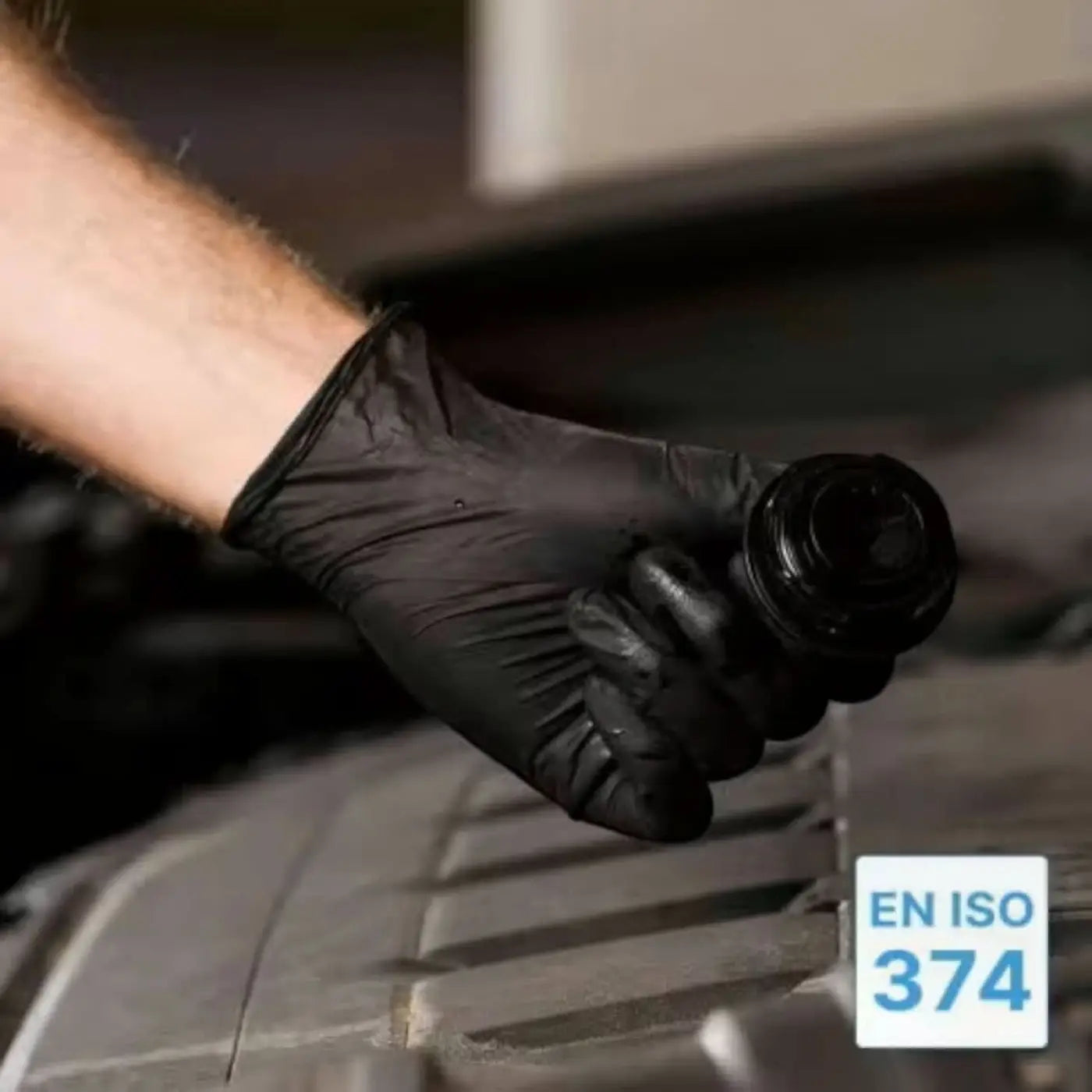 Schwarzer puderfreier arnomed latex-handschuh hält schwarzen zylinderförmigen gegenstand