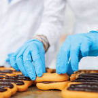 Hände mit Hygonorm "Safe Fit" Nitril-Handschuhe Blau 100 Stück von Franz Mensch verpacken Gebäck hygienisch.