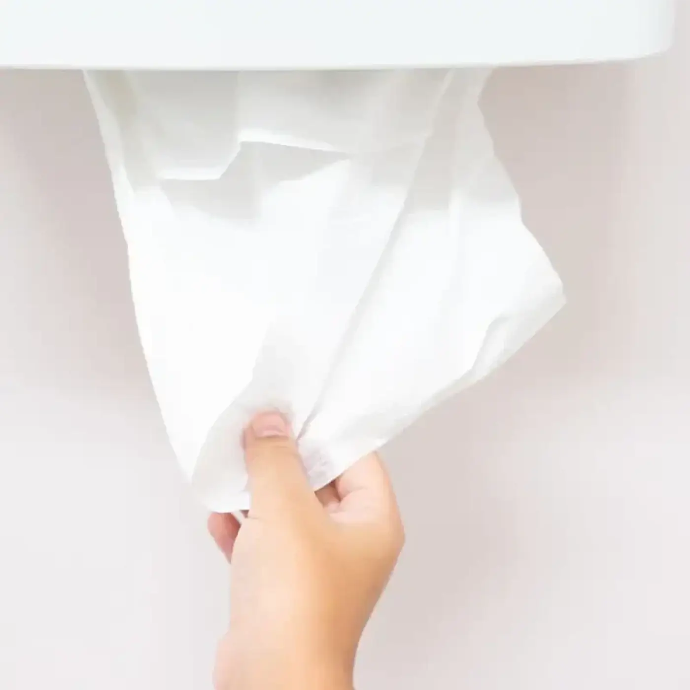 Ein weiches weißes papierhandtuch aus hygoclean 2-lagigem recyclingpapier wird aus einem spender gezogen
