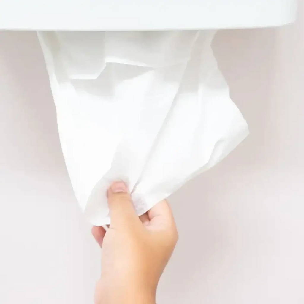 Ein weiches weißes hygoclean papierhandtuch aus 2-lagigem fsc-recyclingpapier wird aus einem spender gezogen