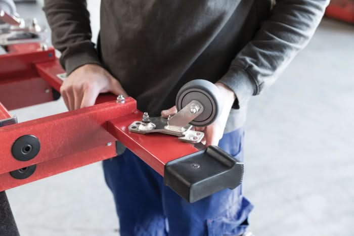 Roter metall-industriewagen mit schwarzem gummirad und silbernen beschlägen im munk nachrüstsatz roll-bar