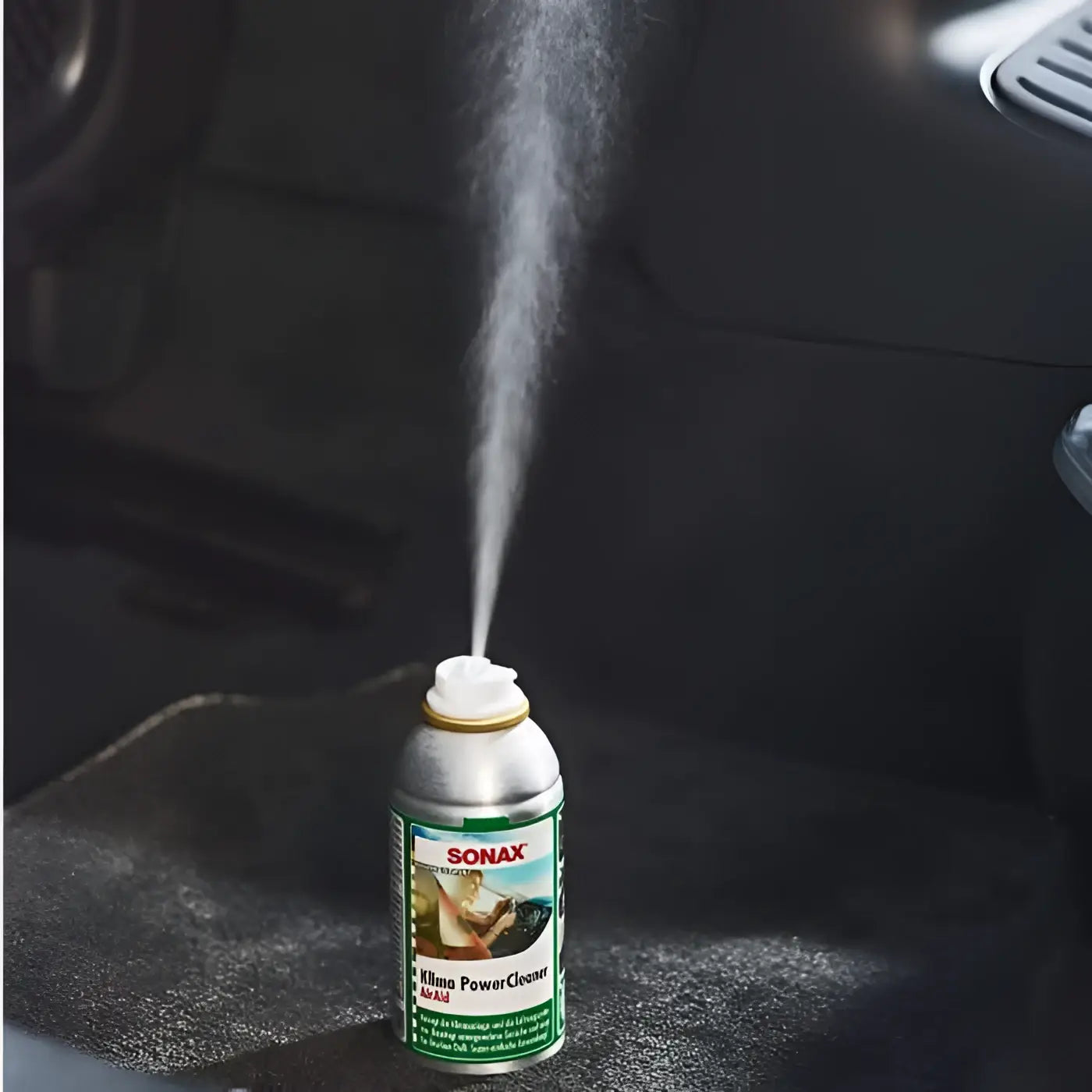 Ein silberner aerosolbehälter von sonax klima powerclean air aid mit grünem und weißem schriftzug 100ml