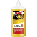 Gelbes flüssiges sonax wasch und wax autoshampoo mit carnauba naturwachs in klarem flaschen mit weißem pumpenspender