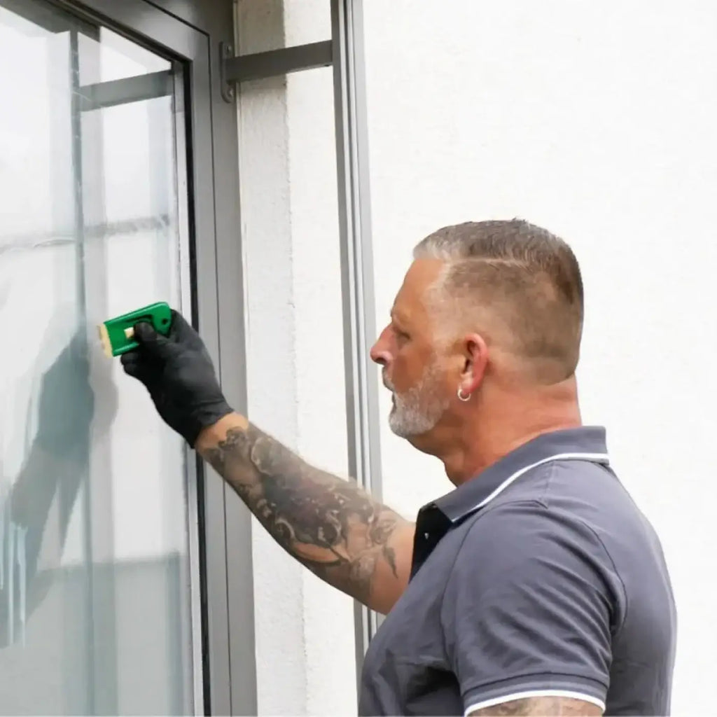 Grünes plastik fensterreinigungsgerät mit gelbem schwammkopf im unger ergotec fensterputzer-komplett-set 6in1 ak015
